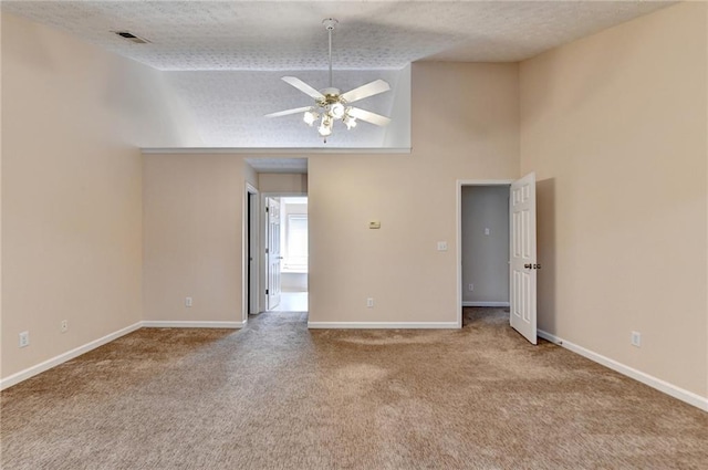 carpeted spare room featuring a ceiling fan, high vaulted ceiling, baseboards, and a textured ceiling