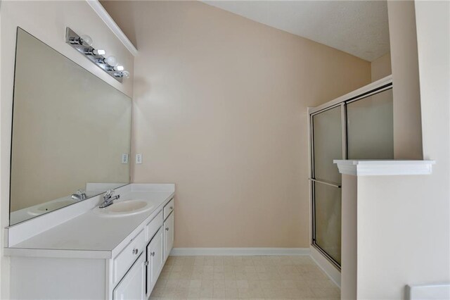 bathroom featuring a stall shower, vanity, baseboards, and tile patterned floors