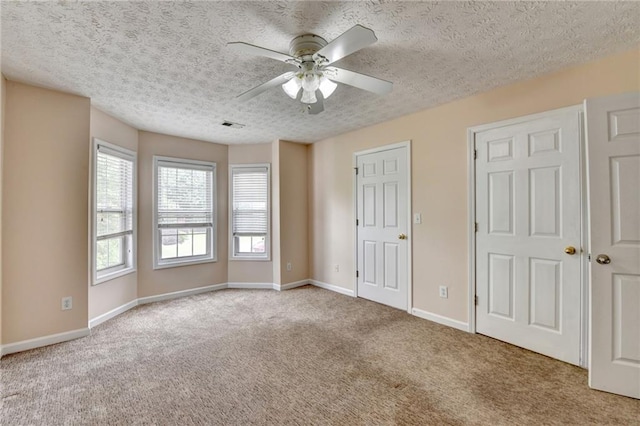 unfurnished bedroom with carpet floors, a textured ceiling, baseboards, and ceiling fan