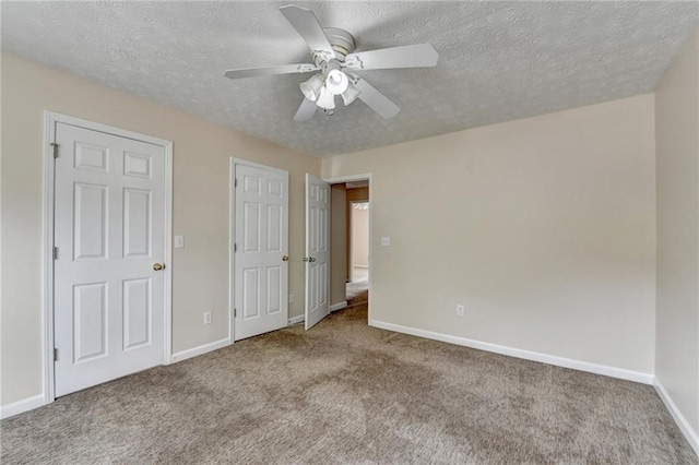 unfurnished bedroom with carpet, baseboards, a textured ceiling, and ceiling fan