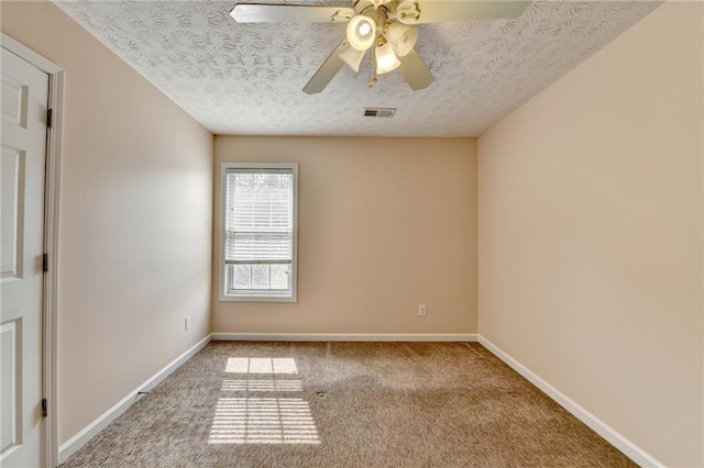 spare room with carpet floors, a textured ceiling, baseboards, and ceiling fan
