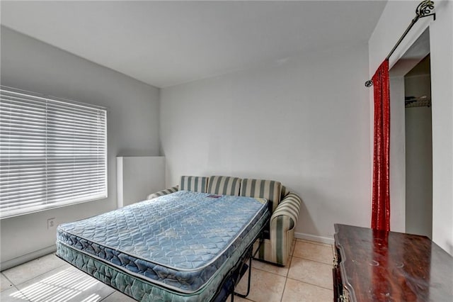 bedroom featuring light tile patterned floors and baseboards