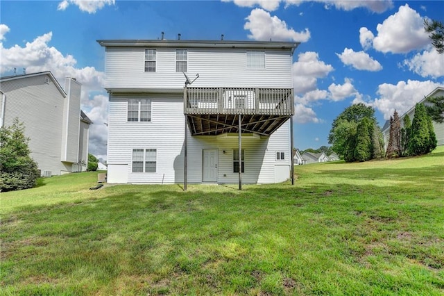 rear view of property featuring a deck and a lawn