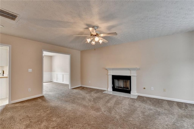 unfurnished living room with carpet, ceiling fan, a textured ceiling, and a fireplace