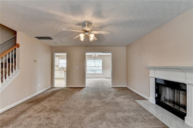 unfurnished living room featuring stairs, ceiling fan, carpet flooring, a textured ceiling, and a fireplace with flush hearth