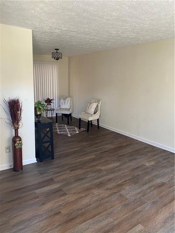 sitting room with a textured ceiling and dark hardwood / wood-style floors