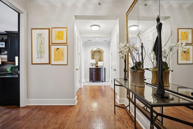 hall with hardwood / wood-style flooring and ornamental molding