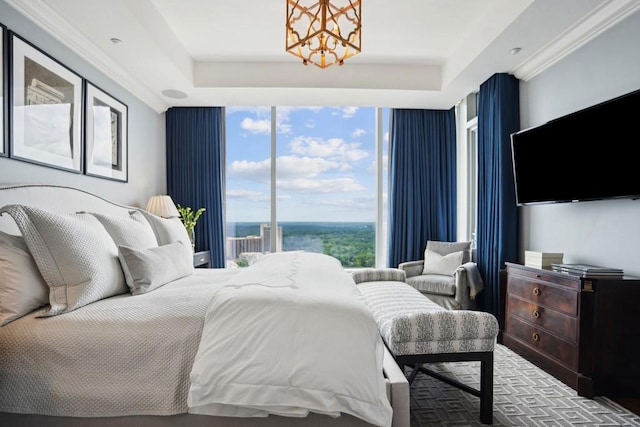 bedroom featuring multiple windows, crown molding, expansive windows, and an inviting chandelier