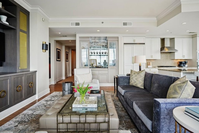 living room with hardwood / wood-style flooring, indoor bar, and ornamental molding