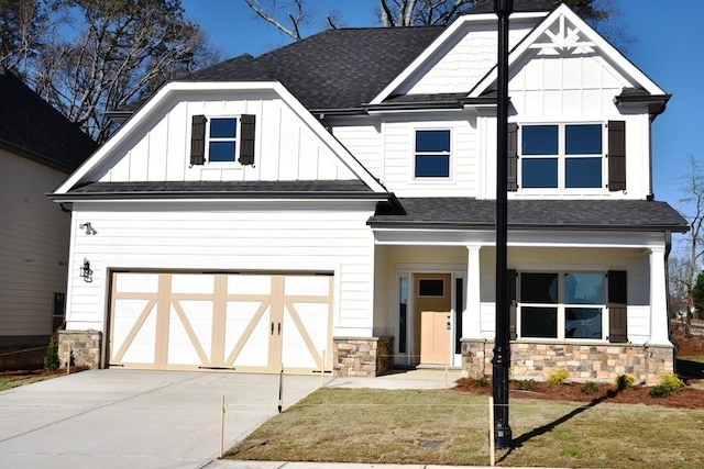 view of front of house with board and batten siding, a shingled roof, and stone siding
