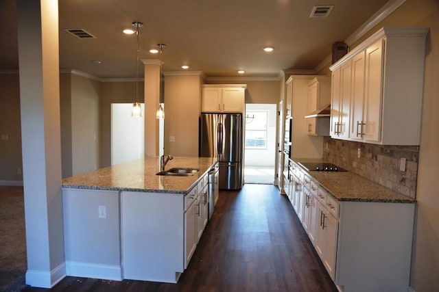 kitchen with appliances with stainless steel finishes, stone counters, a sink, visible vents, and crown molding