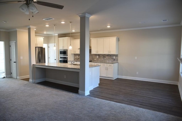 kitchen featuring crown molding, a ceiling fan, appliances with stainless steel finishes, and dark colored carpet