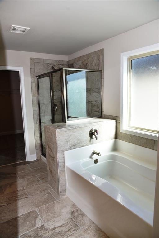 bathroom featuring a stall shower, visible vents, and a bath