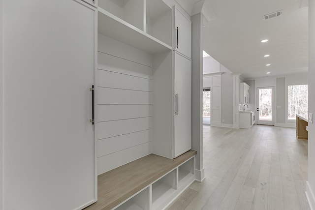 mudroom featuring a sink, light wood-type flooring, baseboards, visible vents, and recessed lighting