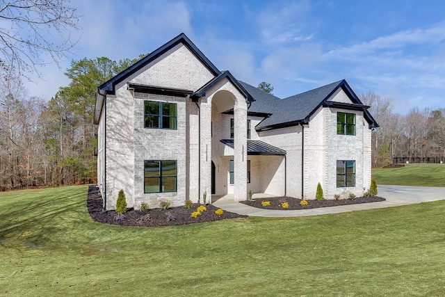 french country style house with a front lawn and brick siding