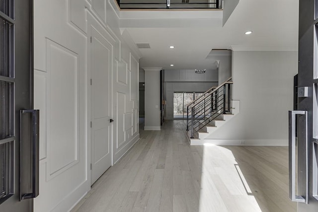 entrance foyer featuring stairs, wood finished floors, baseboards, ornamental molding, and recessed lighting