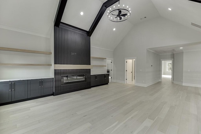 unfurnished living room featuring attic access, light wood-type flooring, baseboards, an inviting chandelier, and high vaulted ceiling