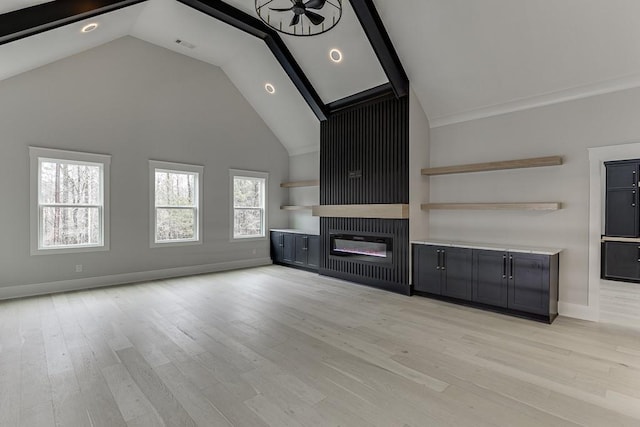 unfurnished living room featuring baseboards, recessed lighting, a glass covered fireplace, light wood-style floors, and high vaulted ceiling