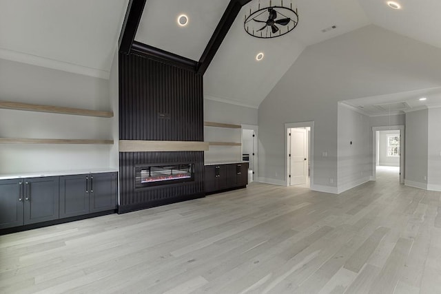 unfurnished living room featuring attic access, light wood-type flooring, baseboards, ornamental molding, and visible vents