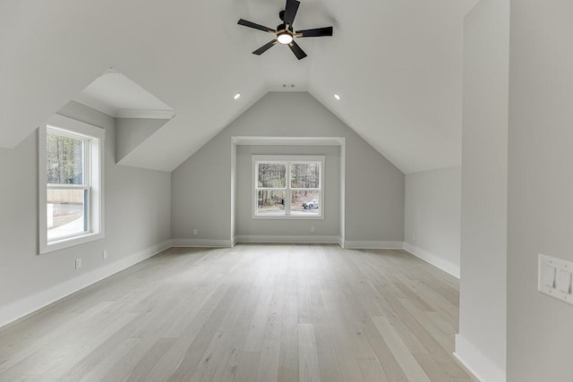 additional living space with lofted ceiling, plenty of natural light, light wood finished floors, and ceiling fan