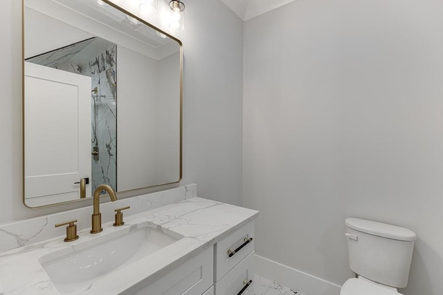 bathroom featuring baseboards, marble finish floor, vanity, and toilet