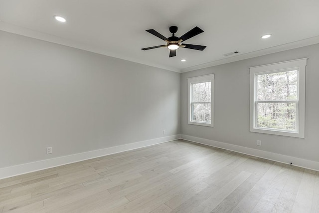 spare room featuring light wood-type flooring, visible vents, a ceiling fan, and baseboards
