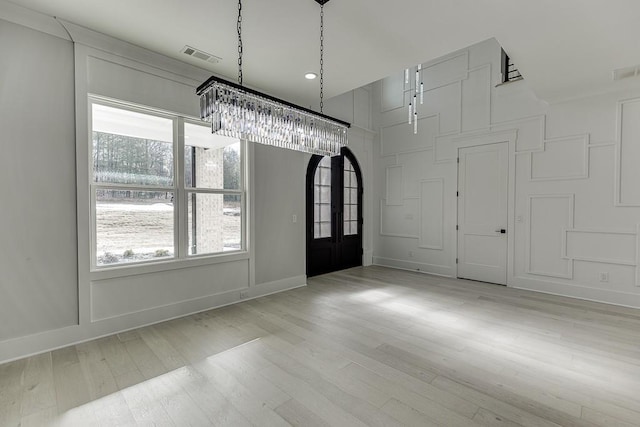 entryway featuring wood finished floors, visible vents, baseboards, and plenty of natural light