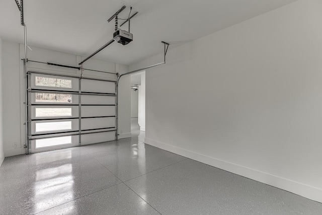 garage featuring a garage door opener and baseboards