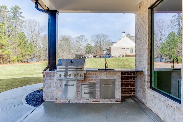 view of patio / terrace featuring grilling area, a sink, and exterior kitchen