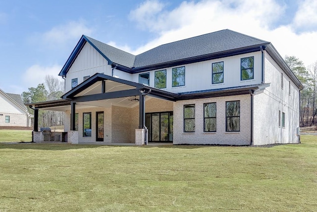 back of property featuring brick siding, a yard, and ceiling fan