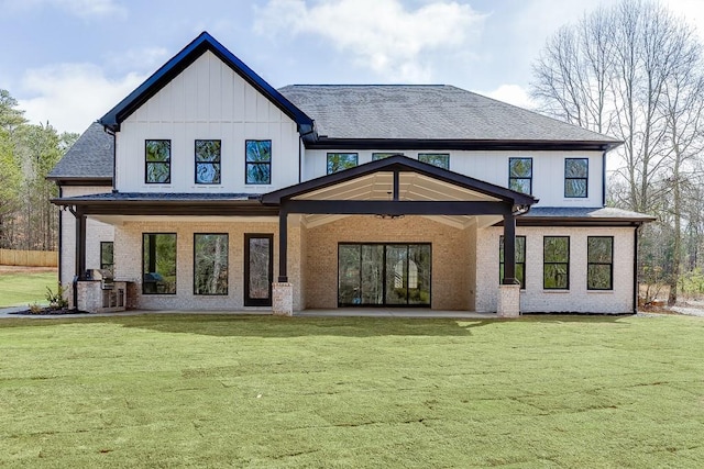 back of property featuring a lawn, a patio, and roof with shingles