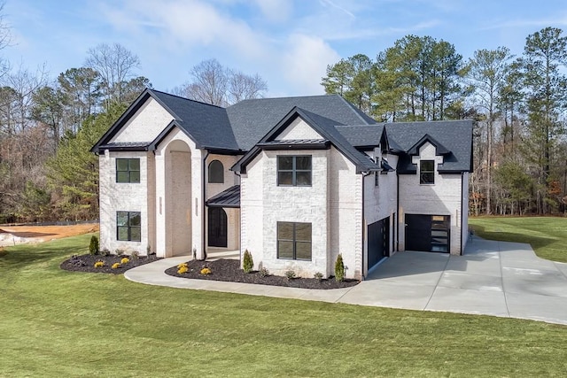 french country style house with a front lawn, driveway, stone siding, a garage, and brick siding
