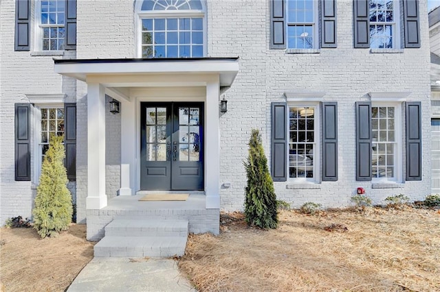 entrance to property featuring brick siding and french doors