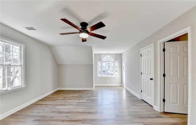 bonus room featuring visible vents, a ceiling fan, light wood-style floors, and a wealth of natural light