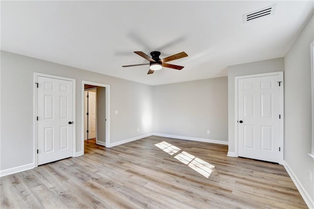 unfurnished bedroom with a ceiling fan, baseboards, visible vents, and light wood-style flooring
