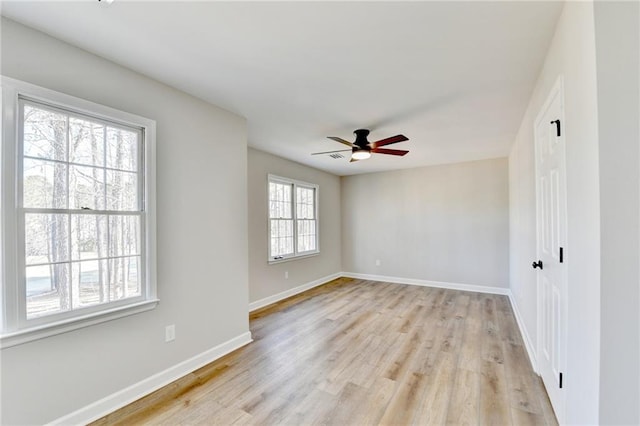 spare room with baseboards, ceiling fan, and light wood-style floors