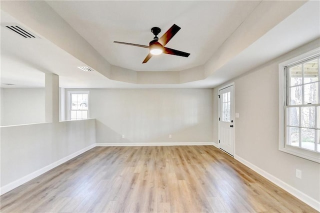 empty room with visible vents, a healthy amount of sunlight, and light wood-style flooring