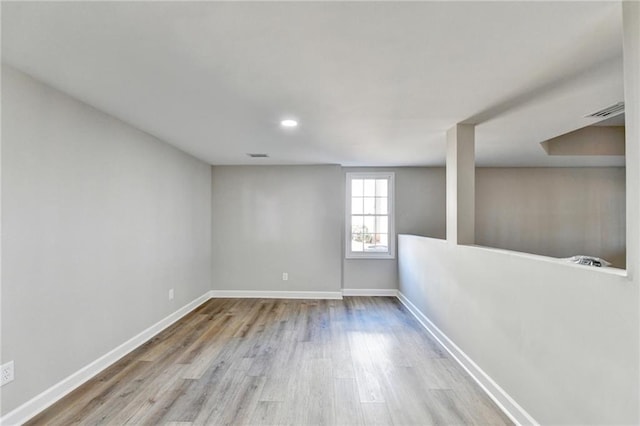 basement featuring baseboards, recessed lighting, wood finished floors, and visible vents
