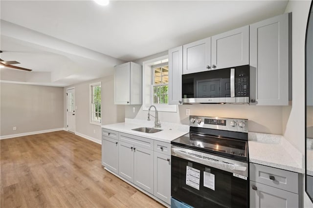5702 Brynwood Cir NW, Acworth, GA 30101 - kitchen featuring stainless steel appliances, a sink, light wood-style flooring, baseboards, and ceiling fan