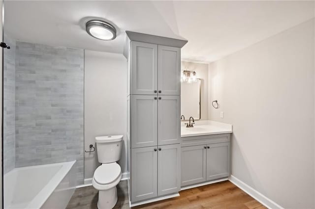 5702 Brynwood Cir NW, Acworth, GA 30101 - bathroom with toilet, wood finished floors, vanity, baseboards, and washtub / shower combination
