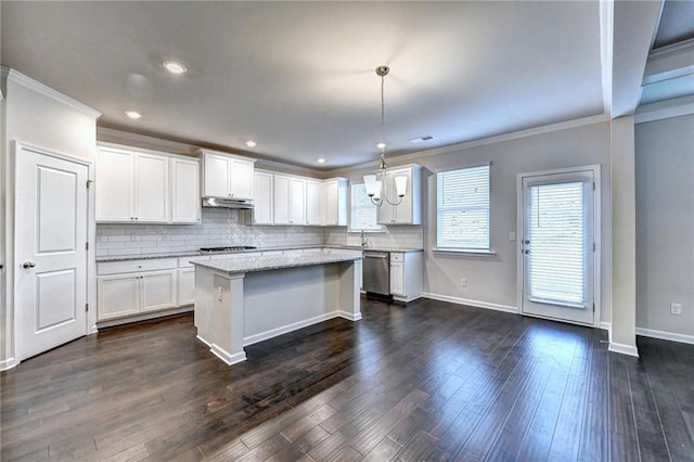 kitchen with sink, a kitchen island, stainless steel dishwasher, pendant lighting, and white cabinets