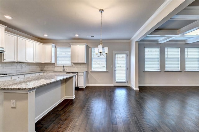 kitchen with beam ceiling, white cabinetry, hanging light fixtures, and ornamental molding