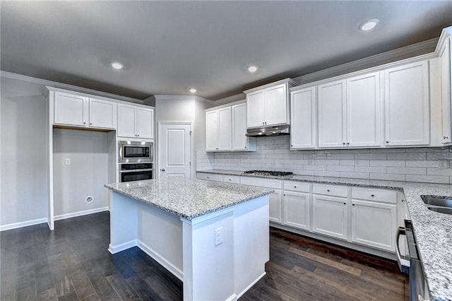 kitchen featuring white cabinetry, stainless steel appliances, light stone counters, dark hardwood / wood-style flooring, and decorative backsplash