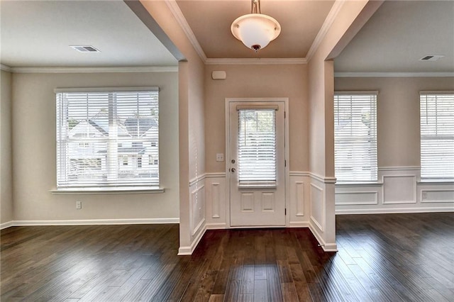 foyer with dark hardwood / wood-style flooring, a wealth of natural light, and ornamental molding