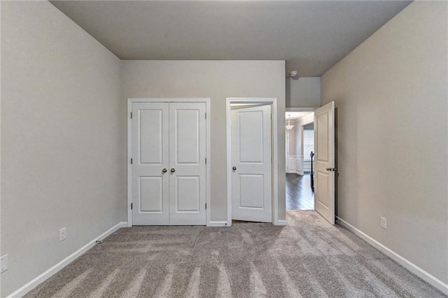 unfurnished bedroom featuring light carpet and a closet