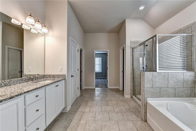 bathroom with tile patterned floors, plus walk in shower, vanity, and lofted ceiling