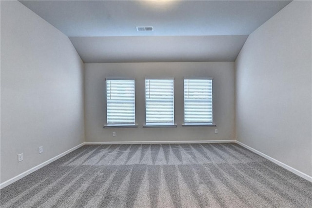 empty room featuring carpet and lofted ceiling