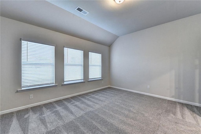 empty room featuring carpet and lofted ceiling