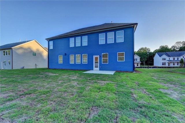 rear view of house with a patio and a yard