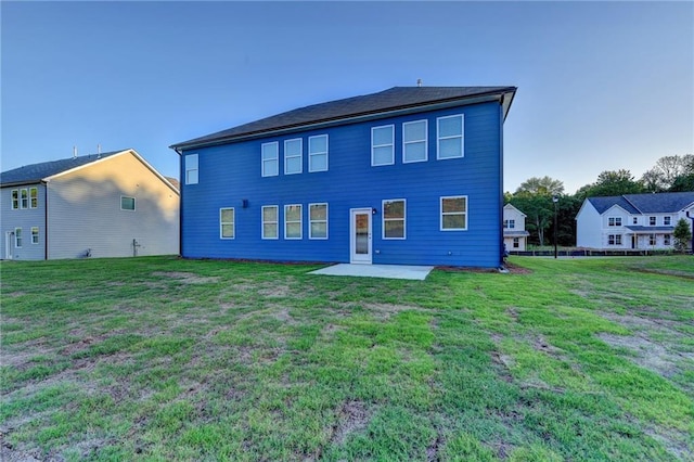 rear view of property featuring a lawn and a patio area